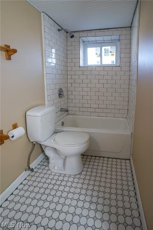 bathroom featuring toilet and tiled shower / bath combo