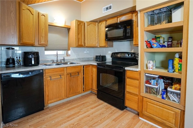 kitchen featuring sink, black appliances, tasteful backsplash, and light hardwood / wood-style flooring