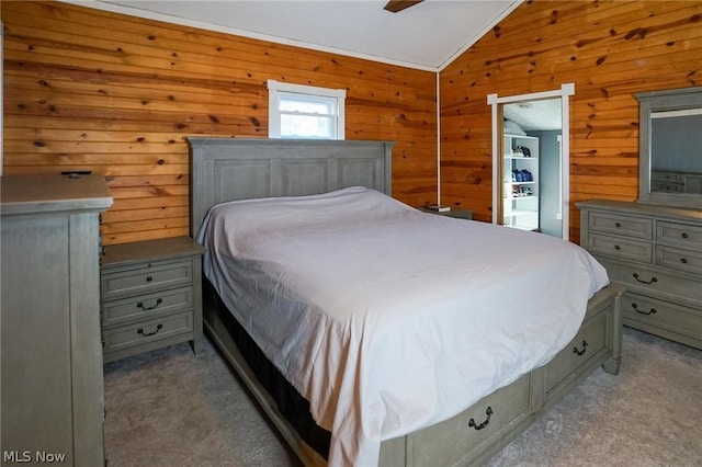 bedroom with ceiling fan, vaulted ceiling, and wooden walls