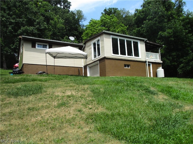 back of property featuring a garage and a yard