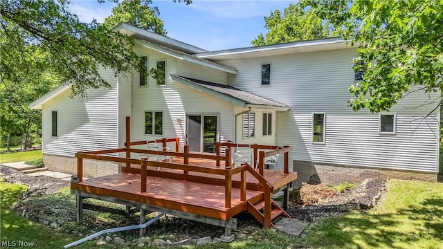 rear view of property with a lawn and a deck