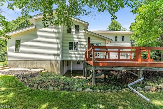 back of property with a yard and a wooden deck