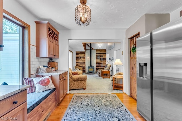 interior space featuring light wood-type flooring, a wood stove, and a textured ceiling