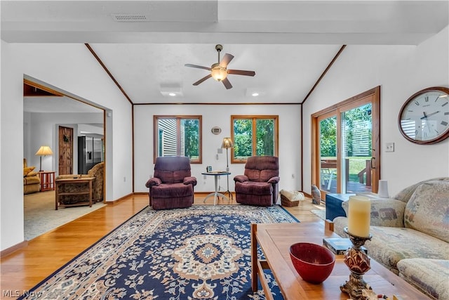 living room featuring ceiling fan, ornamental molding, vaulted ceiling, and light hardwood / wood-style floors