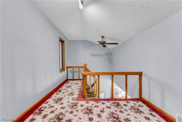 bonus room featuring a textured ceiling, vaulted ceiling, carpet, and ceiling fan