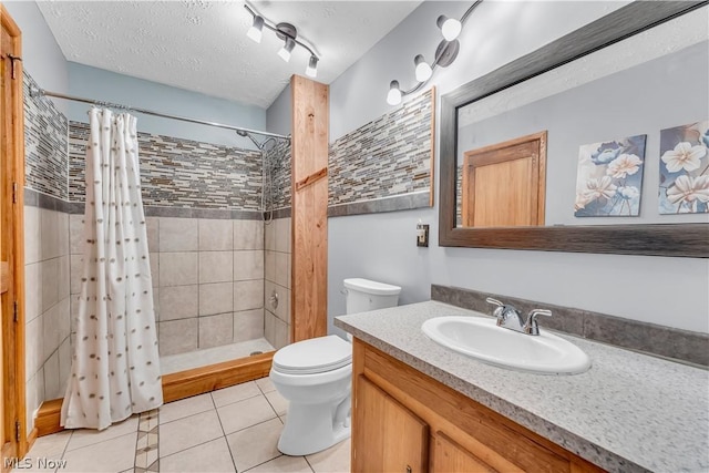 bathroom with a shower with curtain, vanity, a textured ceiling, toilet, and tile patterned floors