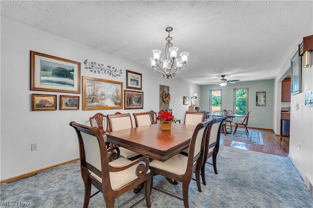 dining room featuring a chandelier, a textured ceiling, and light colored carpet