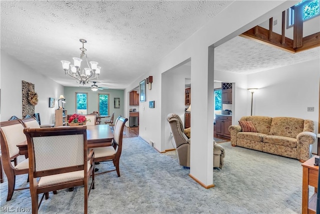 dining space featuring an inviting chandelier, a textured ceiling, and light colored carpet