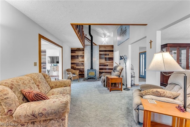 carpeted living room with a textured ceiling and a wood stove