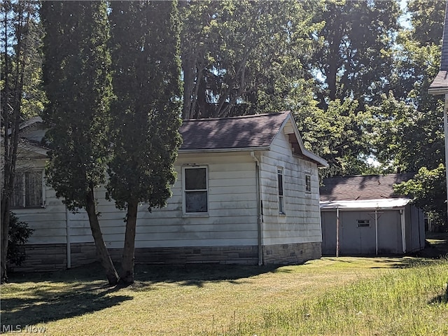 view of side of property with a shed and a yard