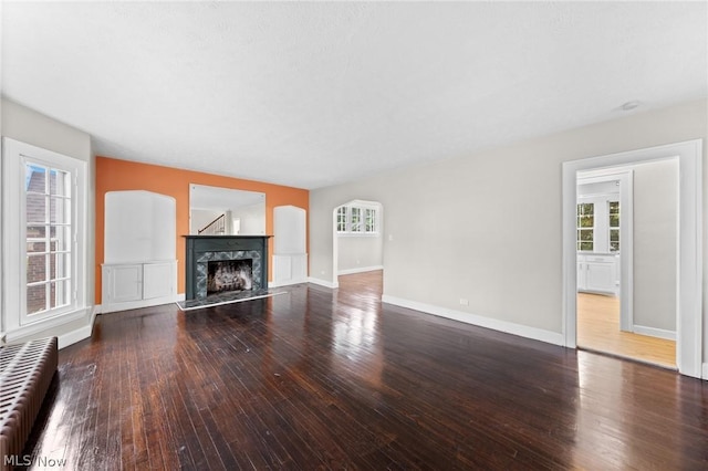 unfurnished living room with a high end fireplace and hardwood / wood-style flooring