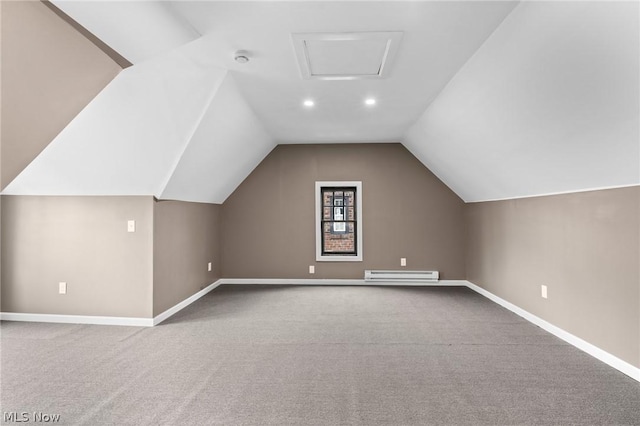 additional living space with vaulted ceiling, a baseboard radiator, and carpet