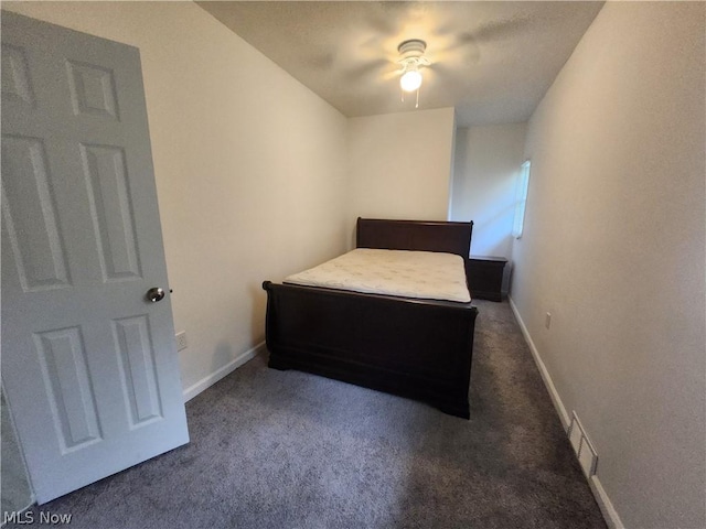 unfurnished bedroom with dark colored carpet and ceiling fan