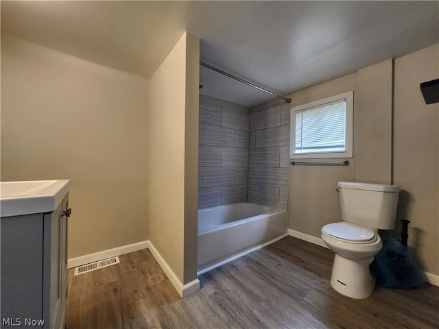 full bathroom featuring wood-type flooring, vanity, toilet, and tiled shower / bath combo