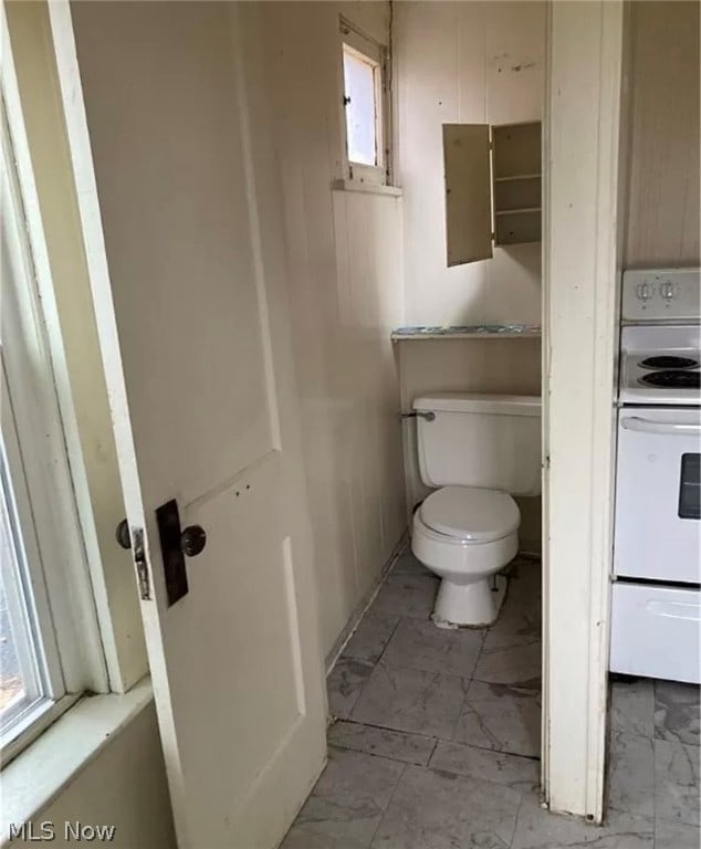 bathroom featuring tile patterned floors, toilet, and a wealth of natural light