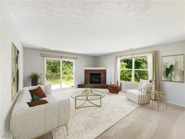 living room with carpet, a textured ceiling, and a brick fireplace