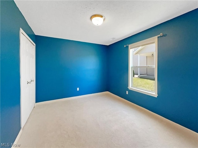 carpeted spare room featuring a textured ceiling