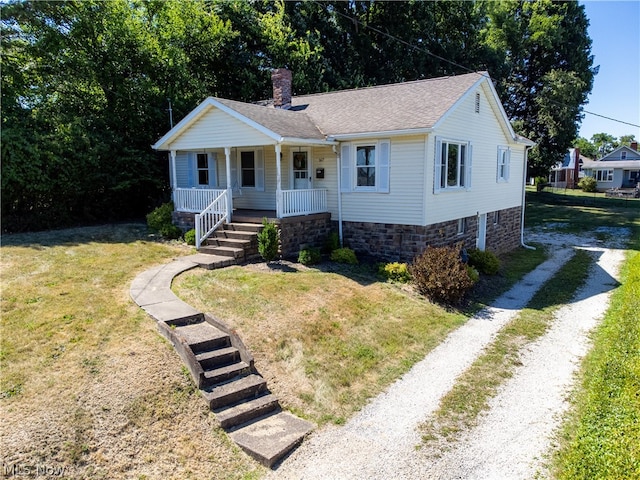 view of front of house with covered porch and a front yard