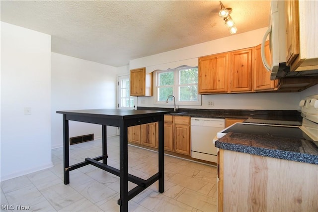 kitchen with a textured ceiling, sink, and white appliances