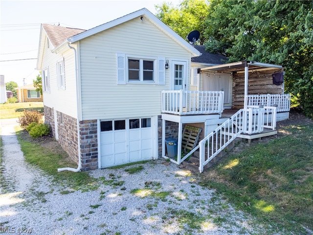 back of house with covered porch and a garage