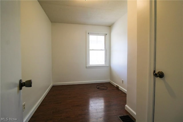 empty room featuring dark wood-type flooring