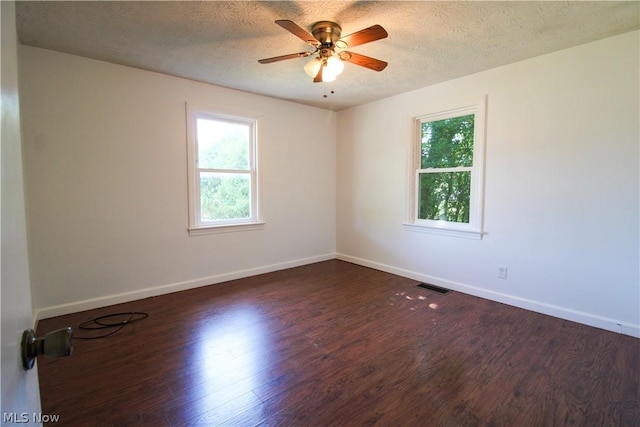 empty room featuring a textured ceiling, dark hardwood / wood-style floors, and ceiling fan