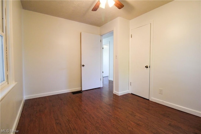 unfurnished bedroom featuring ceiling fan and dark hardwood / wood-style floors