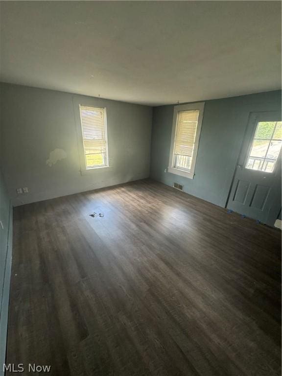 empty room with dark hardwood / wood-style flooring