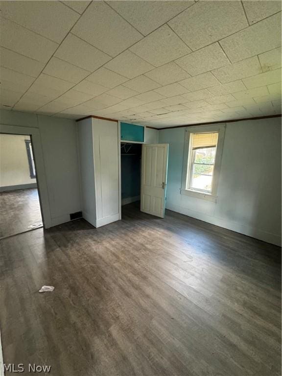 unfurnished bedroom with dark hardwood / wood-style flooring and a closet