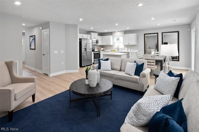 living room with sink and light hardwood / wood-style floors