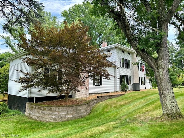 view of side of home with a yard and cooling unit