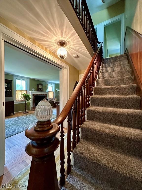 stairway with a brick fireplace