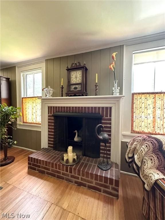 sitting room featuring a fireplace, crown molding, and hardwood / wood-style floors