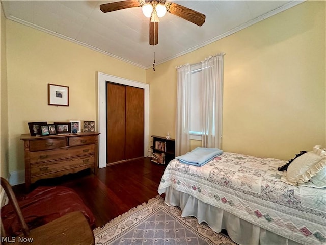 bedroom featuring ceiling fan, dark hardwood / wood-style flooring, crown molding, and a closet