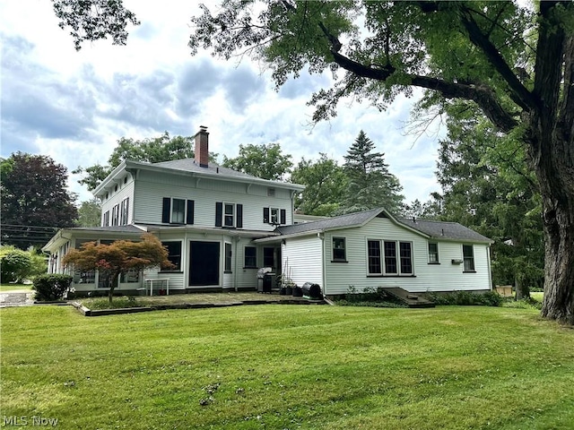 back of house with a lawn