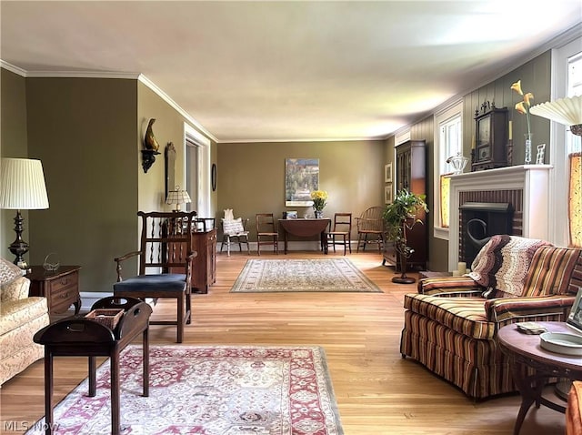 living room featuring crown molding, a fireplace, and light wood-type flooring