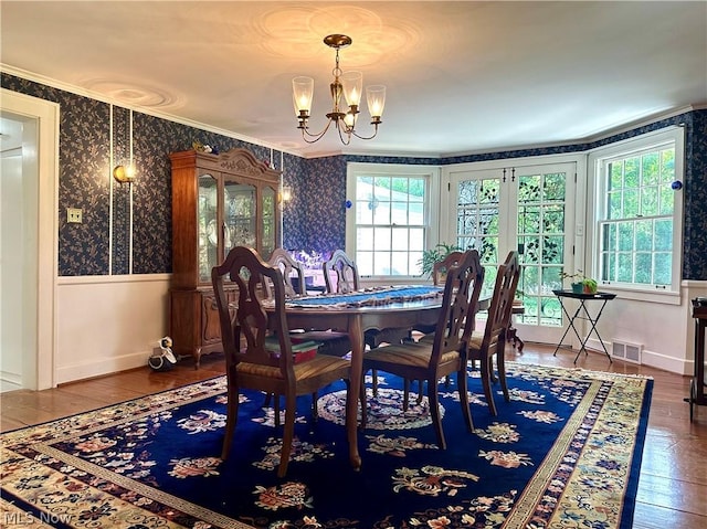 dining room with a notable chandelier, dark hardwood / wood-style floors, and crown molding