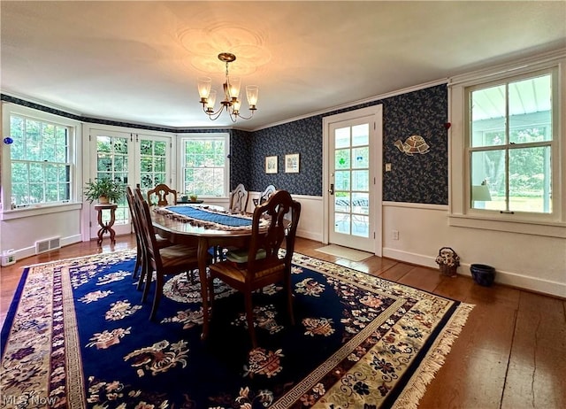 dining room featuring french doors, an inviting chandelier, dark wood-type flooring, and crown molding