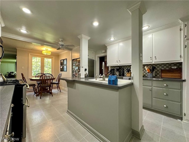 kitchen with white cabinetry, sink, ceiling fan, decorative backsplash, and ornamental molding