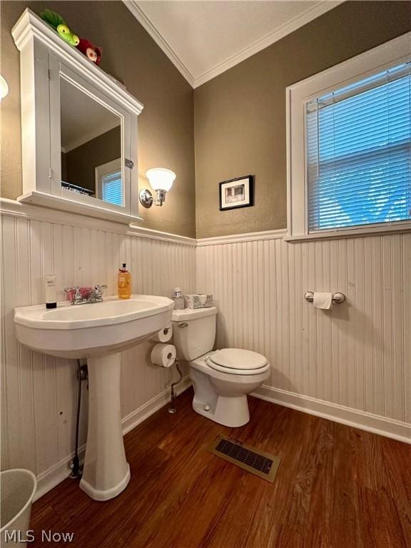 bathroom with hardwood / wood-style flooring, sink, toilet, and crown molding