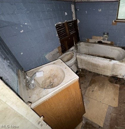 bathroom with vanity, toilet, and a tub