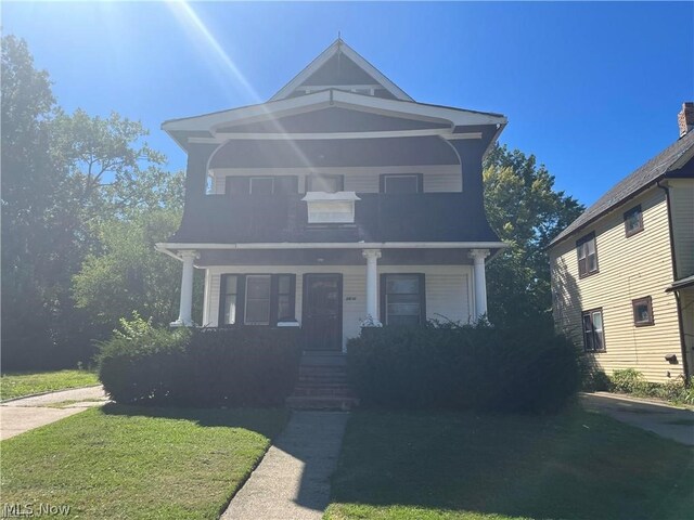 view of property featuring a porch and a front yard