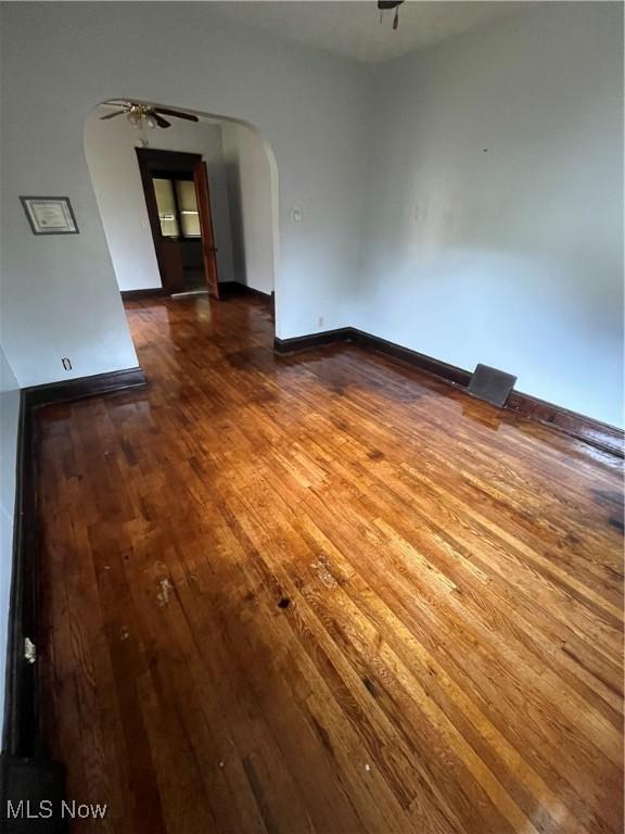 2936 E 128th St, Cleveland, OH 44120 - empty room with arched walkways, wood-type flooring, a ceiling fan, and baseboards