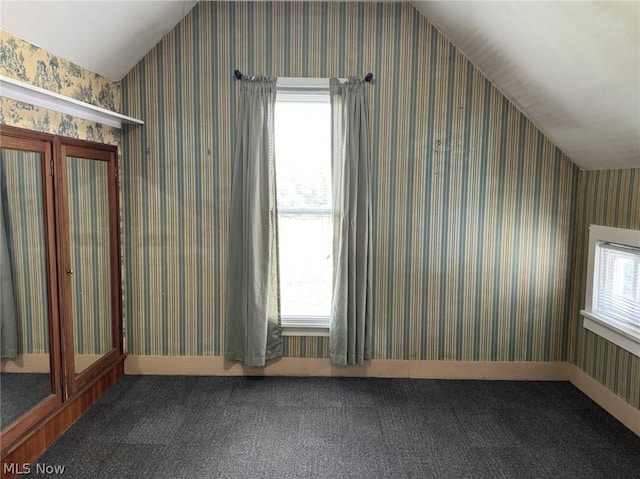 bonus room with carpet flooring, plenty of natural light, and vaulted ceiling