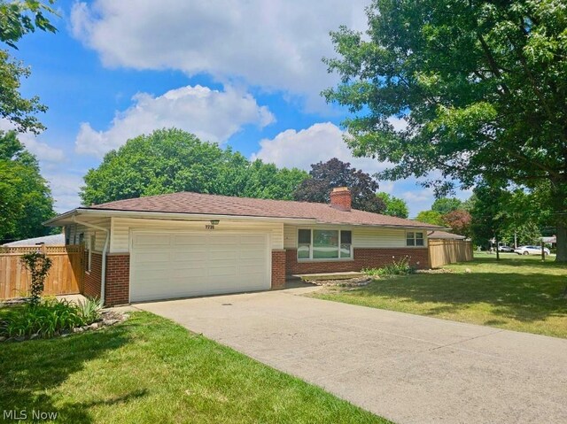 single story home featuring a garage and a front lawn