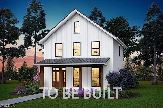 back house at dusk featuring covered porch and a yard