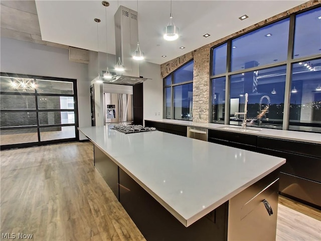 kitchen with a spacious island, appliances with stainless steel finishes, island range hood, and decorative light fixtures
