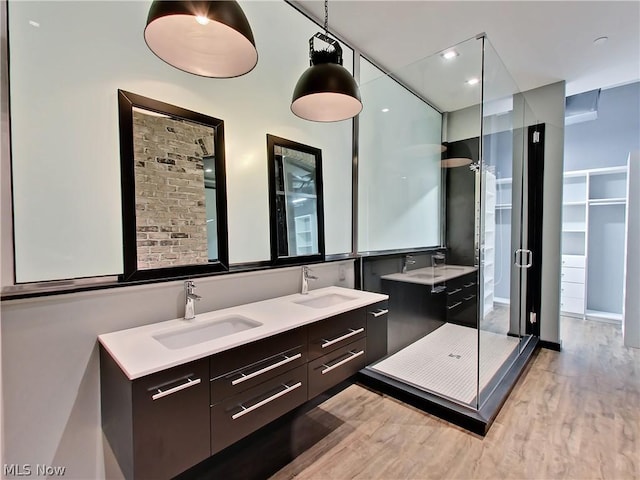 bathroom with vanity, a shower with shower door, and hardwood / wood-style floors