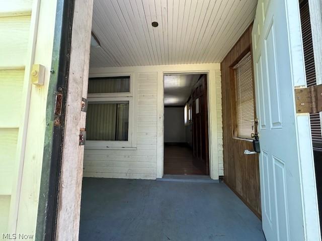 hall with wood walls and concrete flooring