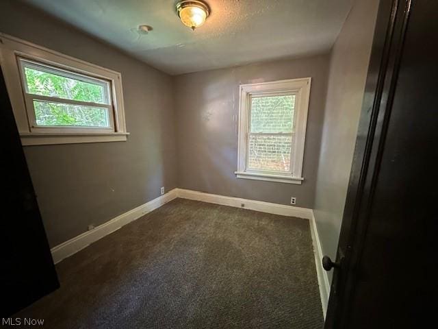 unfurnished room with a textured ceiling